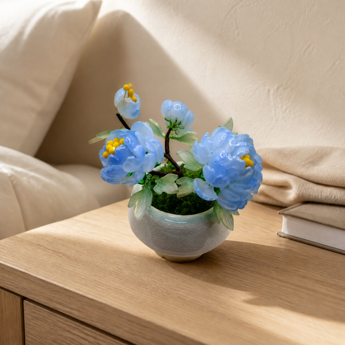 Sky blue glass peony arrangement on a nightstand