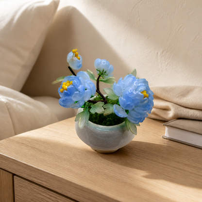 Sky blue glass peony arrangement on a nightstand