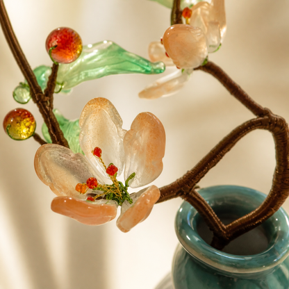 Close-up of blush glass peach blossoms and green leaves